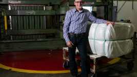 PrimaLoft Product Engineer Robert Dempsey with the first bale of fine denier high performance PrimaLoft biodegradable fibre